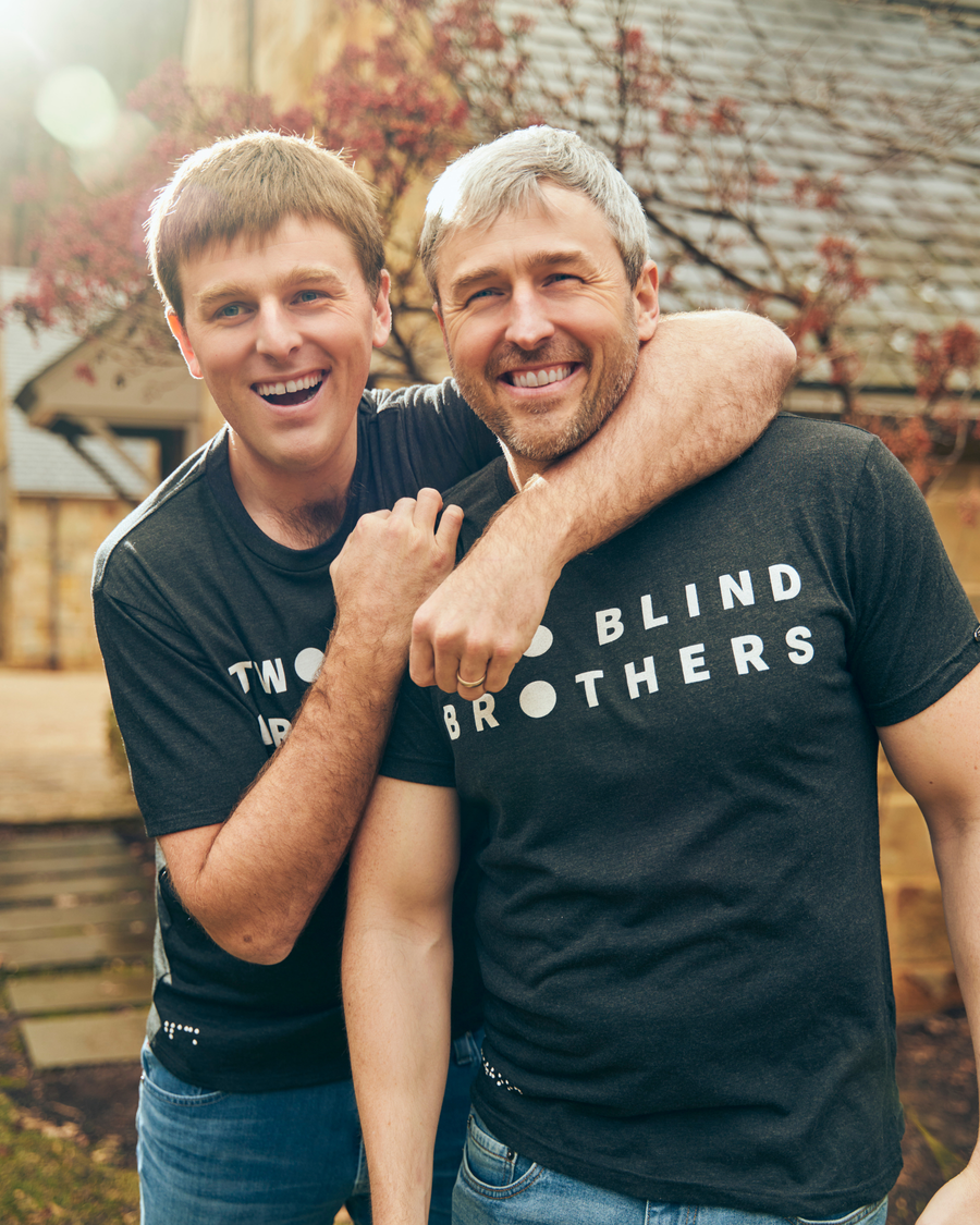brad and bryan manning smiling in two blind brothers logo tees.